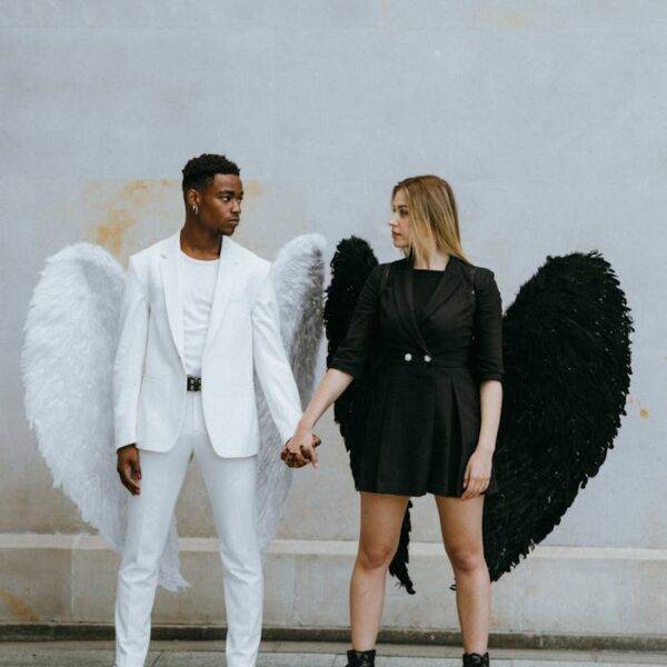 Two people dressed as contrasting angels, one in white and one in black, symbolizing the balance between bad credit and improving credit scores with credit cards