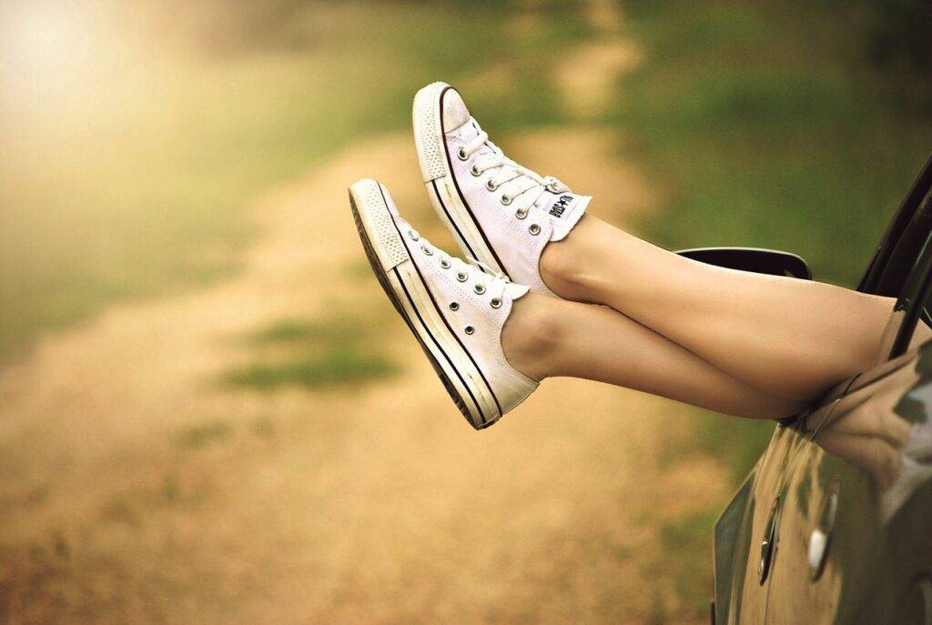 Person relaxing with feet out of car window on a sunny road trip - Car Finance Guide in the UK