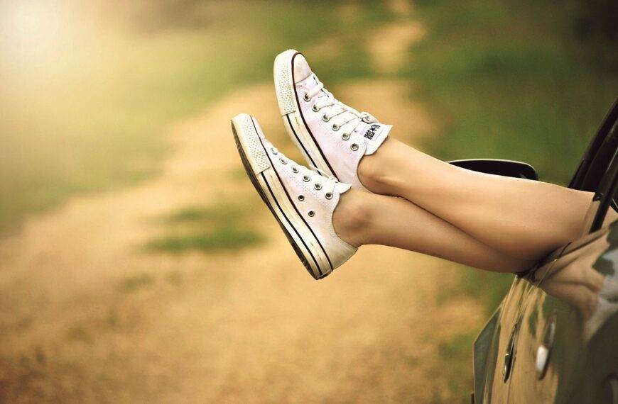 Person relaxing with feet out of car window on a sunny road trip - Car Finance Guide in the UK