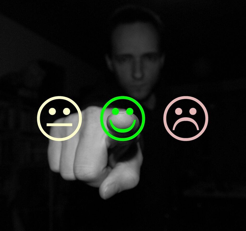 Person pointing at a smiling face icon among neutral and sad face icons, symbolizing the impact of credit rating and credit score in the UK