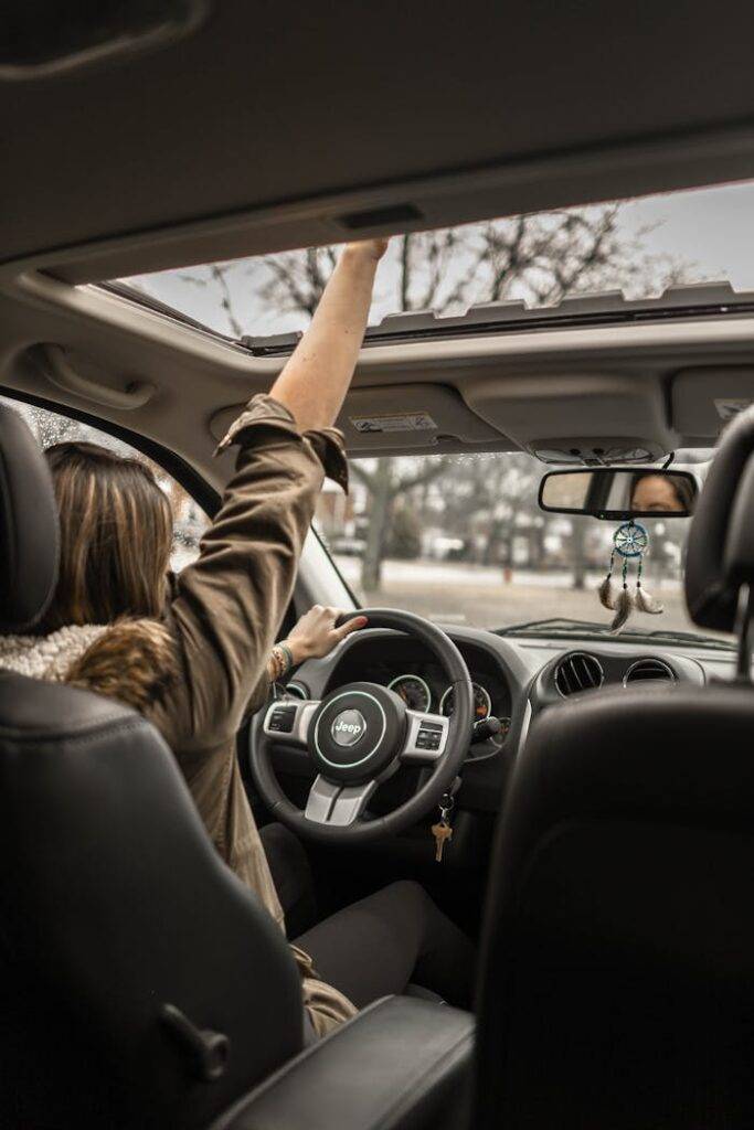 Driver inside a car with hand reaching out the sunroof, symbolizing early termination options for car finance in the UK including PCP, HP, and leasing