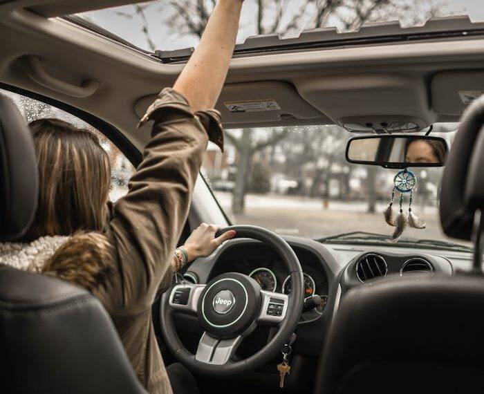 Driver inside a car with hand reaching out the sunroof, symbolizing early termination options for car finance in the UK including PCP, HP, and leasing