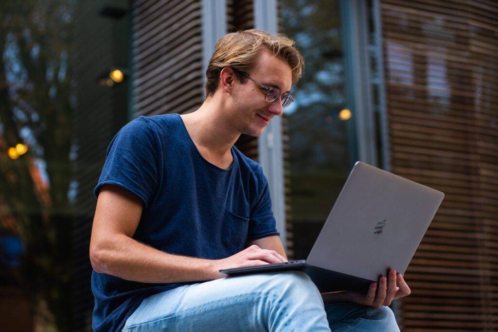 Young man using a laptop outdoors, representing the rise of online learning and the most popular categories in 2024