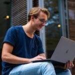 Young man using a laptop outdoors, representing the rise of online learning and the most popular categories in 2024