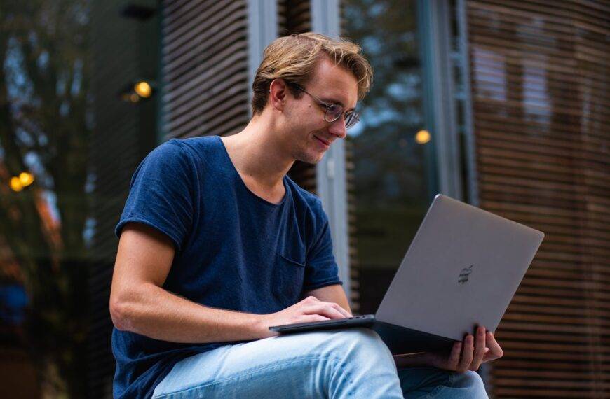 Young man using a laptop outdoors, representing the rise of online learning and the most popular categories in 2024