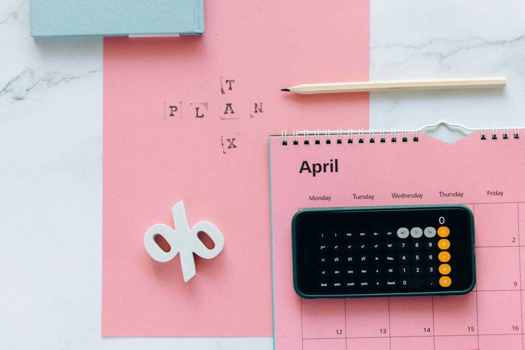 Calculator on a pink calendar with the word "Plan" written above, symbolizing the regulation of Buy Now Pay Later services in the UK and a new chapter in consumer credit