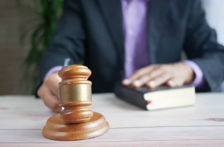 Close-up of a judge's gavel with a person in a suit holding a book, symbolizing the legal implications of the Renters' Reform Bill and its impact on the UK rental market