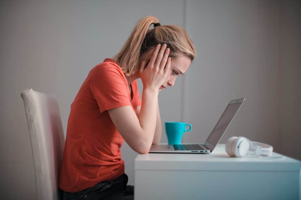 Worried student looking at a laptop, symbolizing the growing concern of rising credit card debt among students in 2024