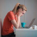 Worried student looking at a laptop, symbolizing the growing concern of rising credit card debt among students in 2024