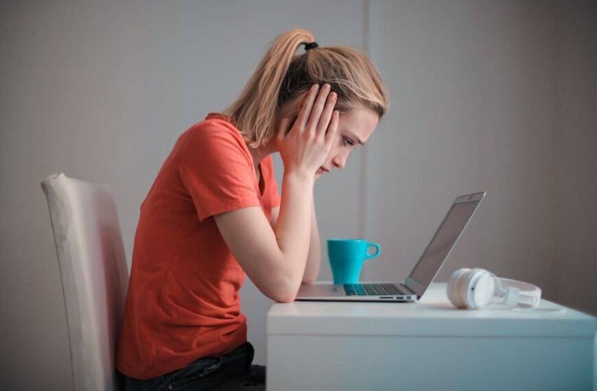 Worried student looking at a laptop, symbolizing the growing concern of rising credit card debt among students in 2024