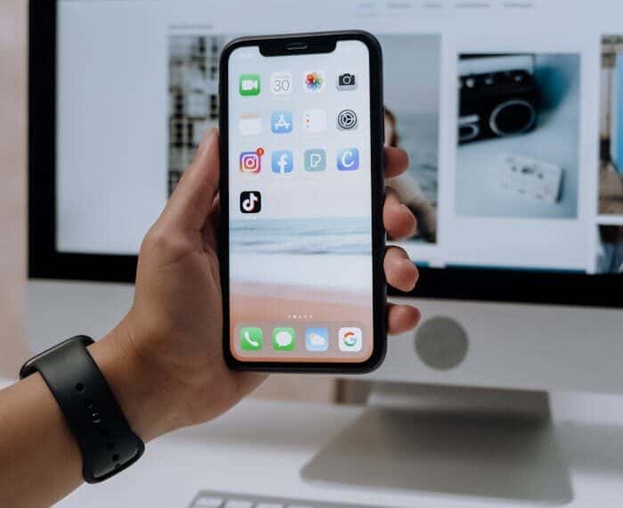 Person holding a smartphone with various apps displayed, representing the top budgeting apps and platforms of 2024