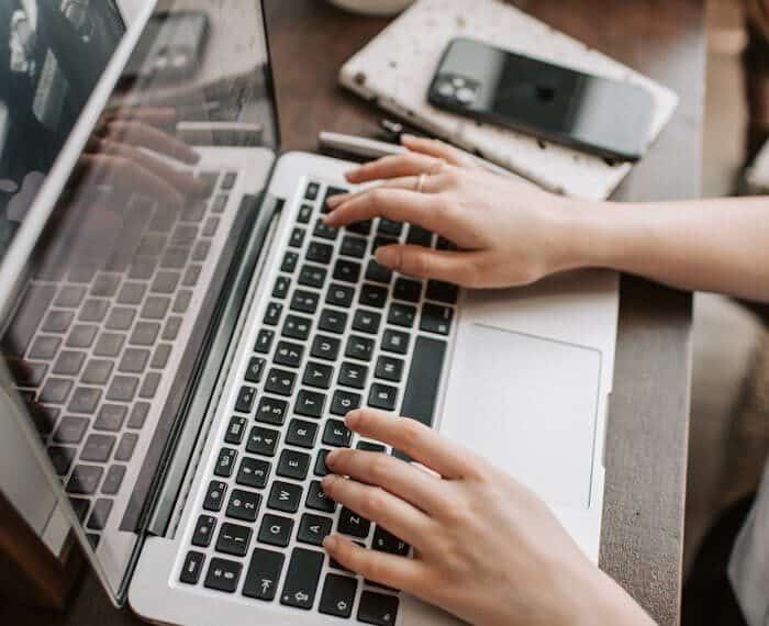 Person typing on a laptop, representing online learning from top elite schools on edX, offering Ivy League education at an affordable cost