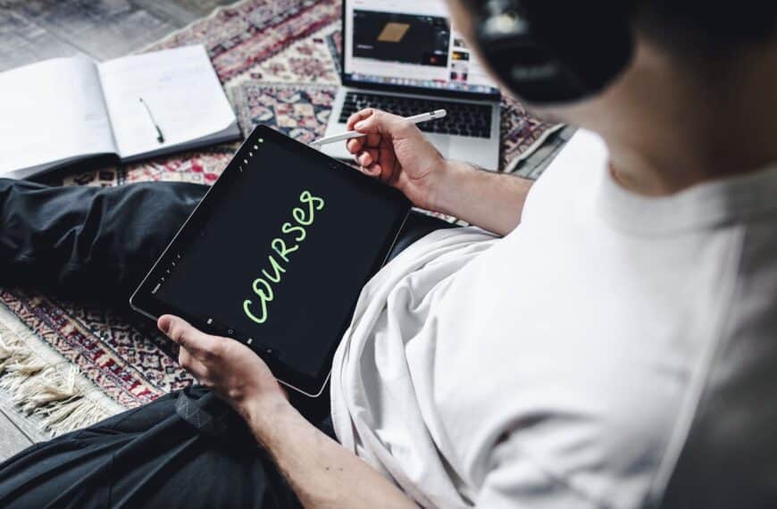 Person using a tablet with the word "Courses" on the screen, representing online learning through top universities and business schools on Coursera