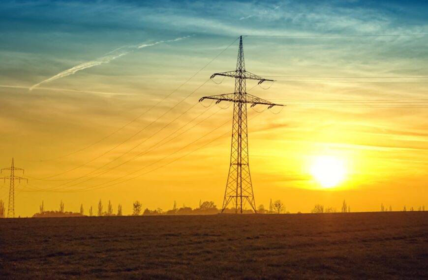 Sunset over power lines, symbolizing the journey of UK energy prices, trends, and the energy cap over the last 5 years