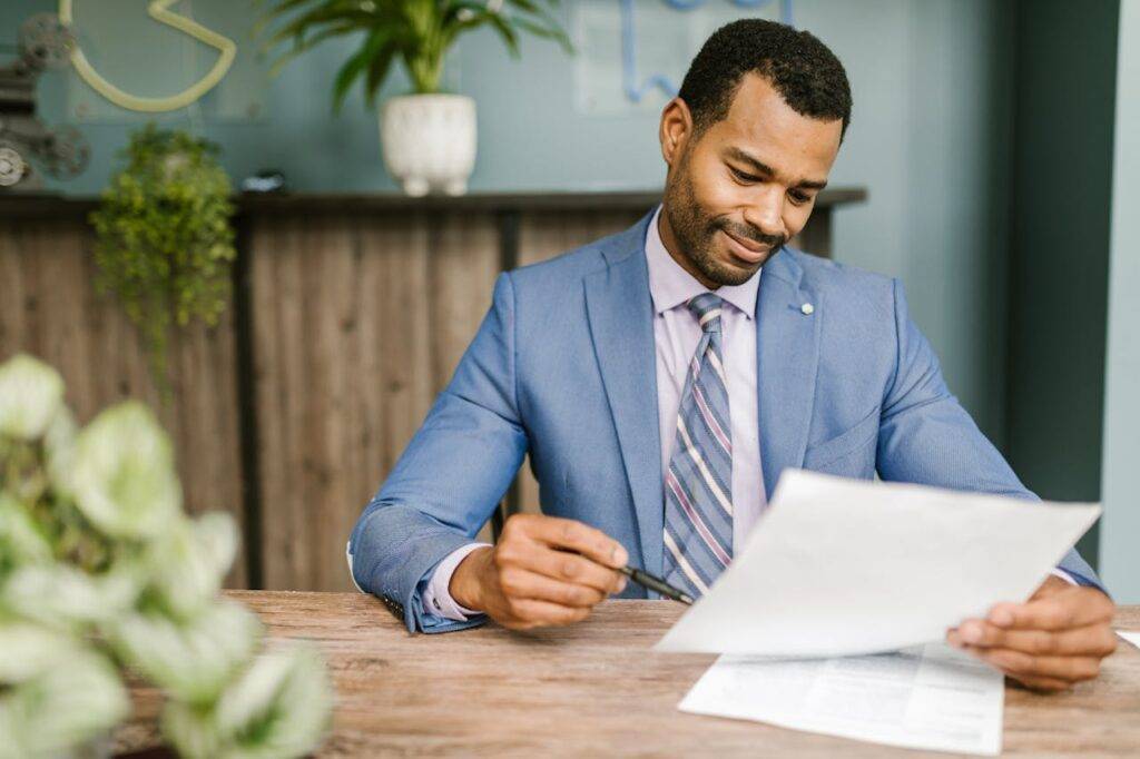 Smiling professional reviewing documents at a desk, representing the role of mortgage brokers in the UK