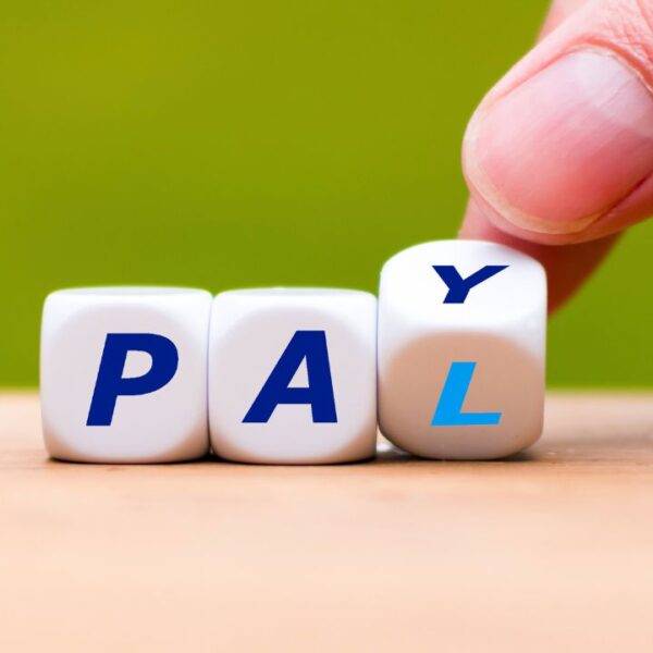 Hand adjusting dice to spell "PAY," symbolizing expert strategies to unlock the full potential of PayPal for maximum benefits