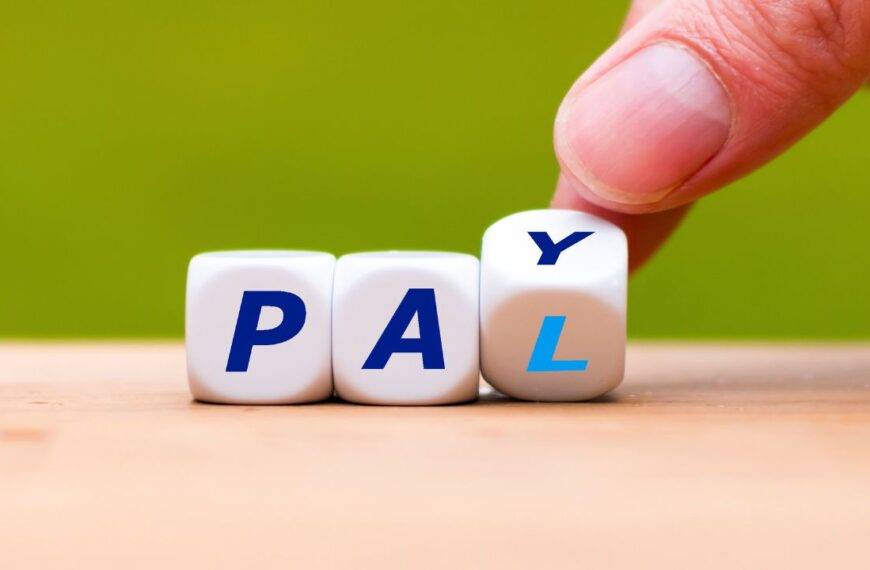 Hand adjusting dice to spell "PAY," symbolizing expert strategies to unlock the full potential of PayPal for maximum benefits