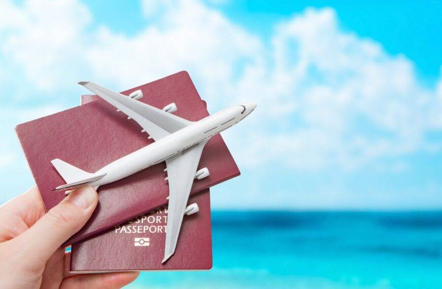 A hand holding passports and a toy airplane against a blue sky, symbolizing travel rewards and maximizing Avios points value