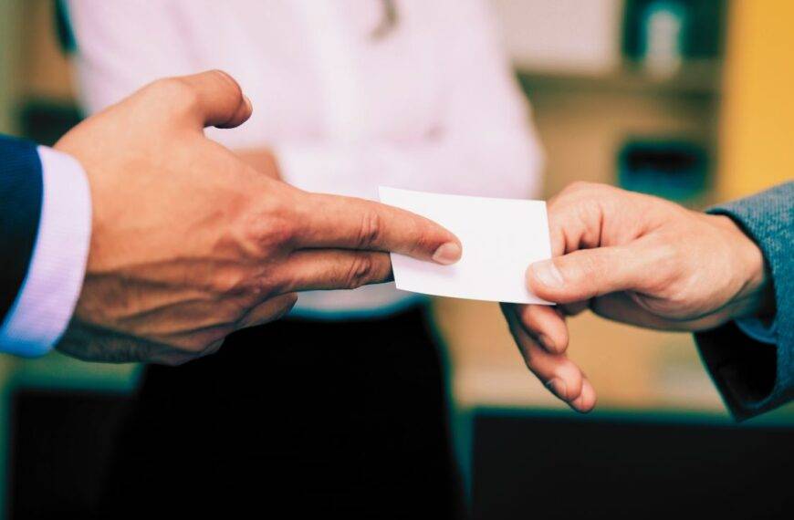 Close-up of a business card exchange, highlighting modern technologies like QR codes and NFC