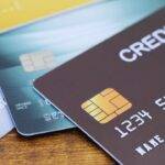 Close-up of various credit cards, including business credit cards, laid out on a wooden surface.