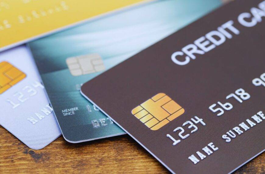 Close-up of various credit cards, including business credit cards, laid out on a wooden surface.