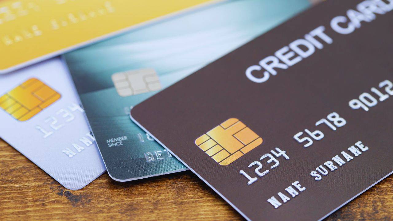 Close-up of various credit cards, including business credit cards, laid out on a wooden surface.