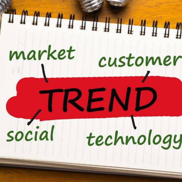 A notepad with the word "Trend" and key factors like market, customer, social, and technology, representing job trends for 2030