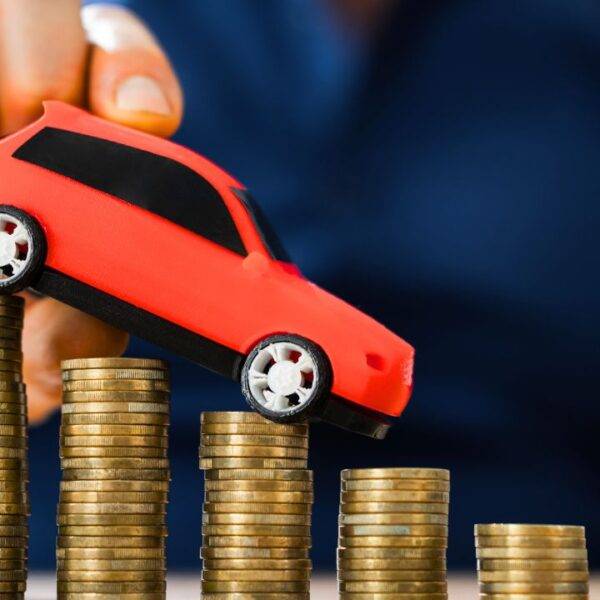 Toy car placed on stacked coins, representing gap insurance and vehicle value in case of theft