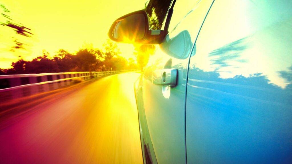 A car speeding down a road, highlighting the concept of insuring a vehicle you don't own