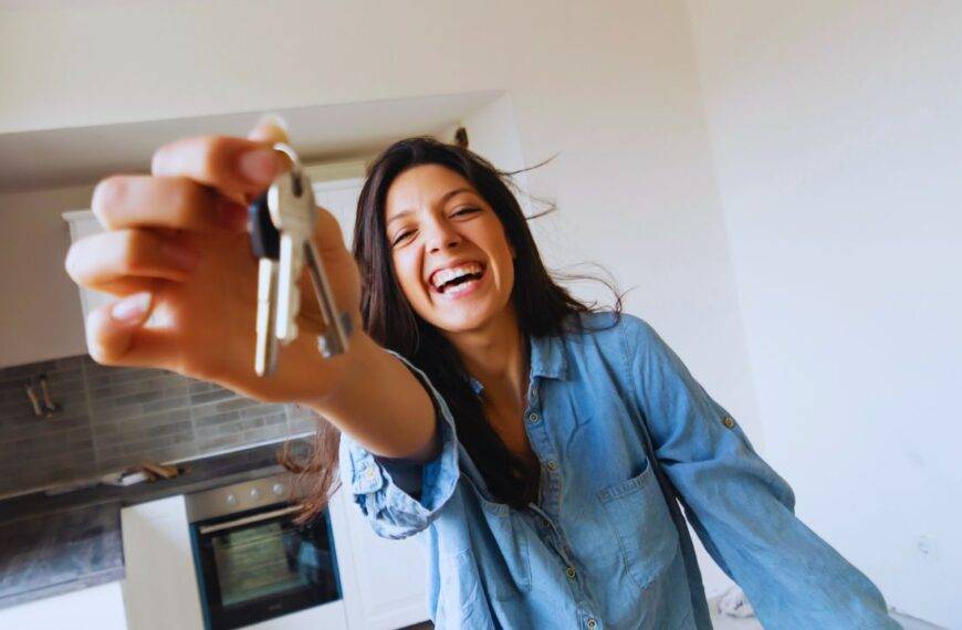 A happy woman holding keys in a new home, representing the concept of shared ownership in the UK