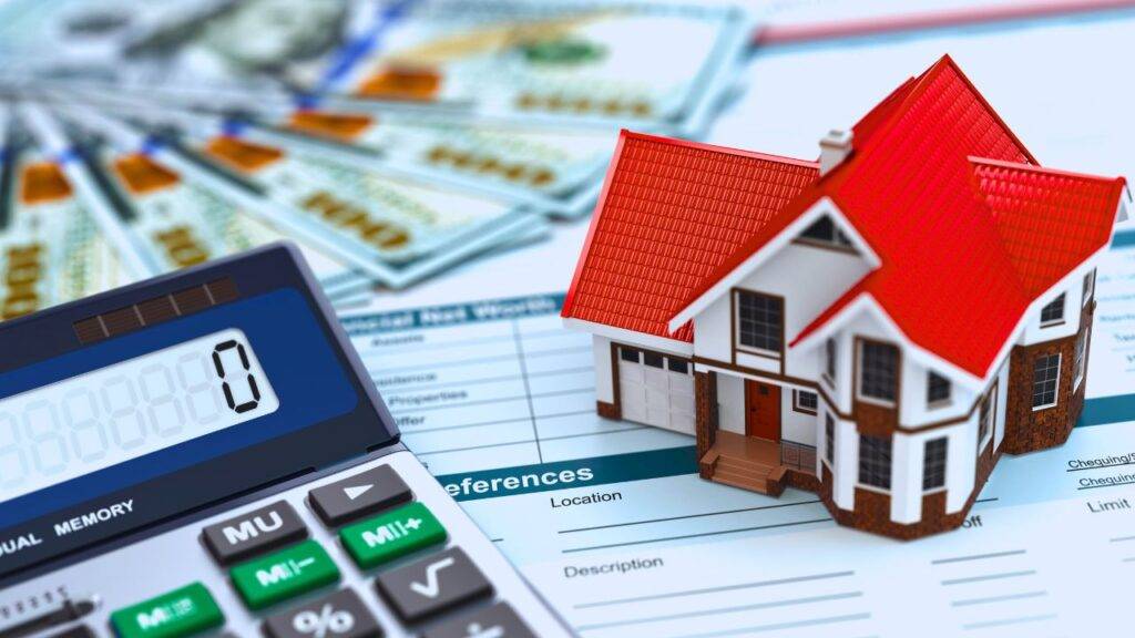 A small house model, calculator, and financial documents representing self-employed mortgage requirements.