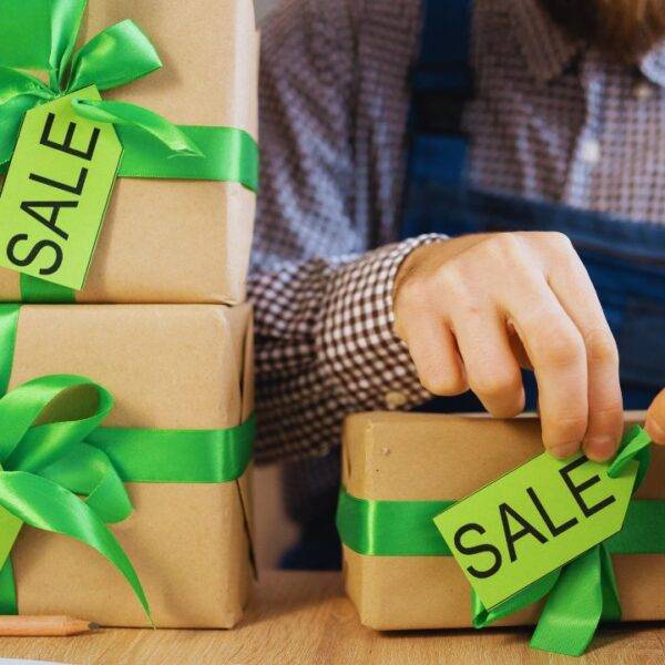 Person packaging items with sale tags, representing a successful dropshipping business