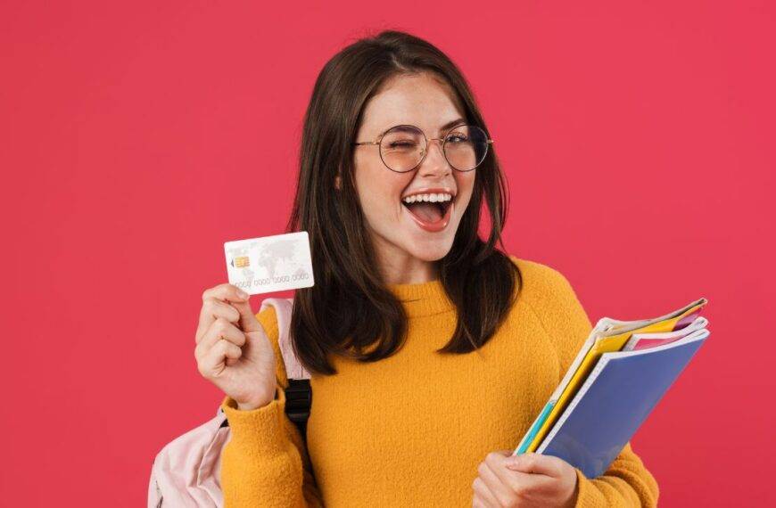 A student happily holding a credit card while carrying school supplies, highlighting the best credit card options for students